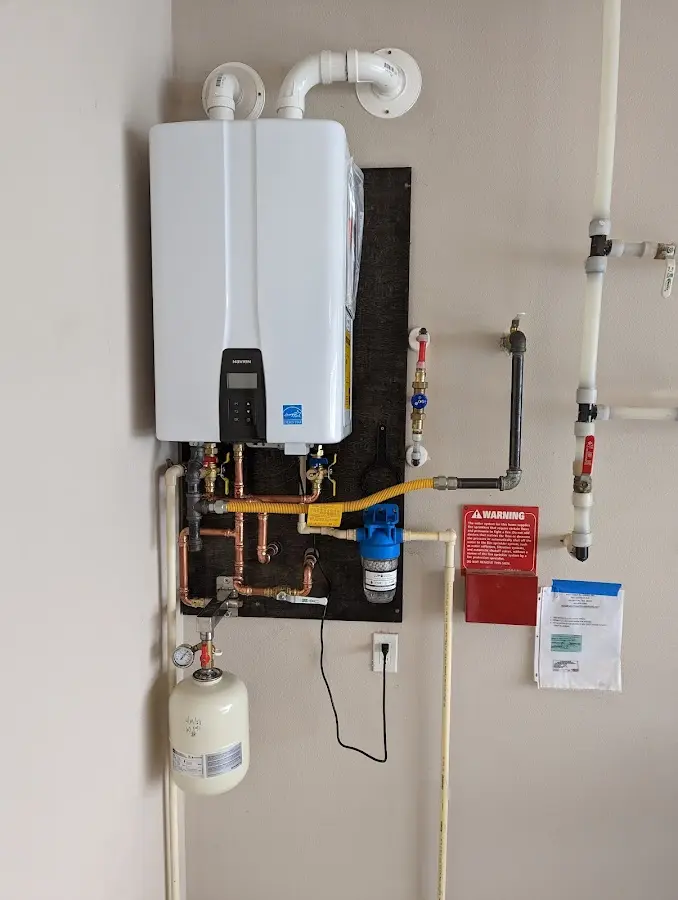 Professional plumber installing copper piping in a Monee home